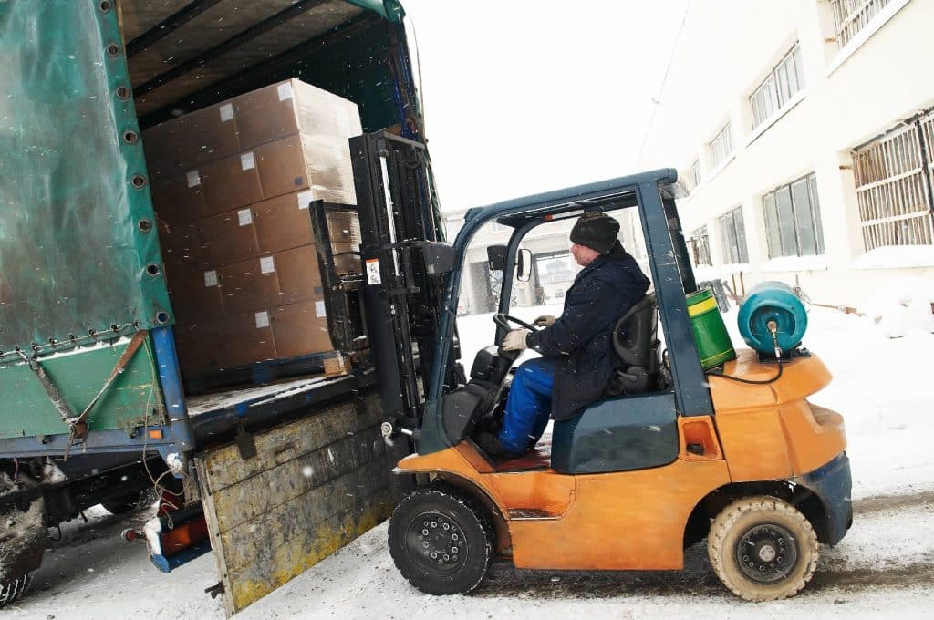 Ekspres Vikar, Fleksibel Fastansættelse, sløret billede af mand der kører en gaffeltruck på et lager